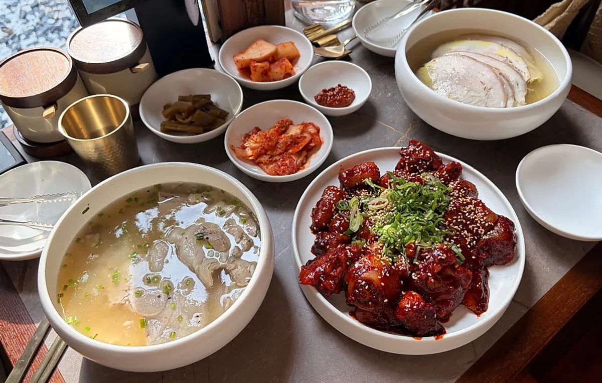 A table spread of Anok's pork gomtang, Pyeongyang naengmyeon, and braised pork tail