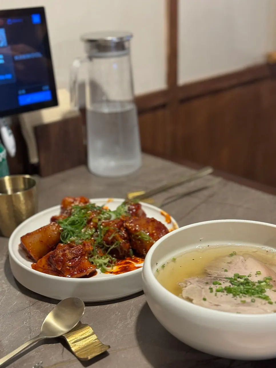 Table with gomtang and Pyongyang naengmyeon side by side