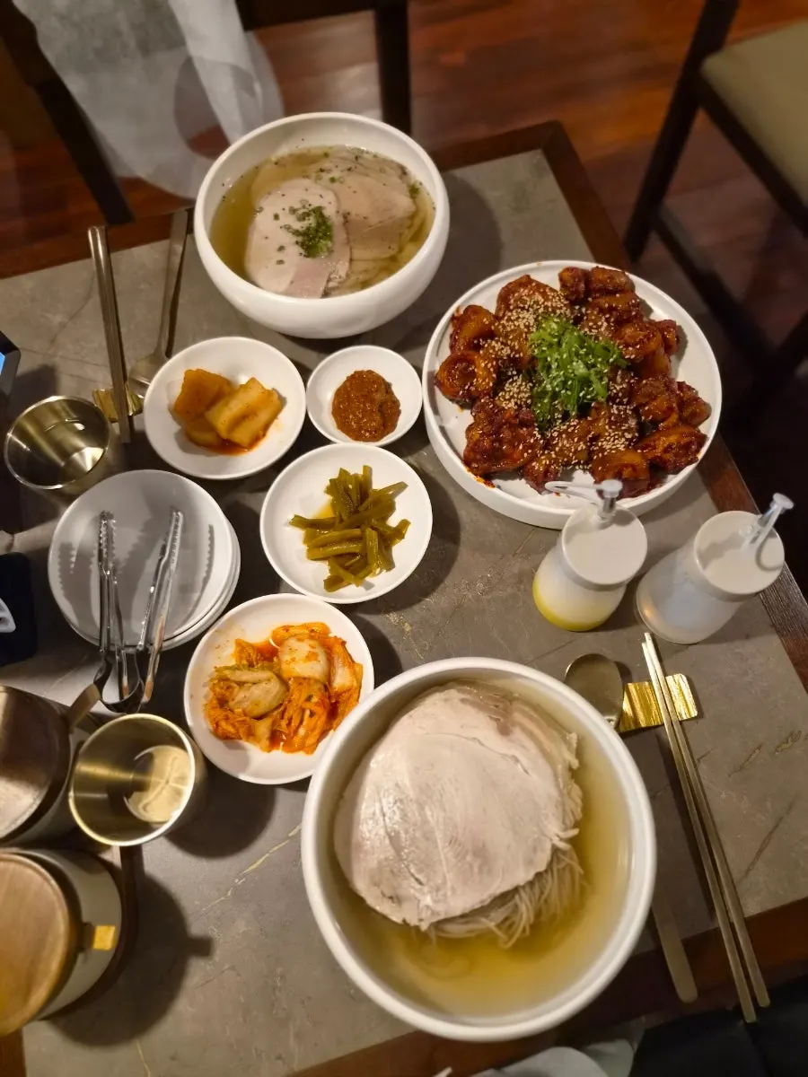Table spread of ordered naengmyeon, clear gomtang, and braised pork tail
