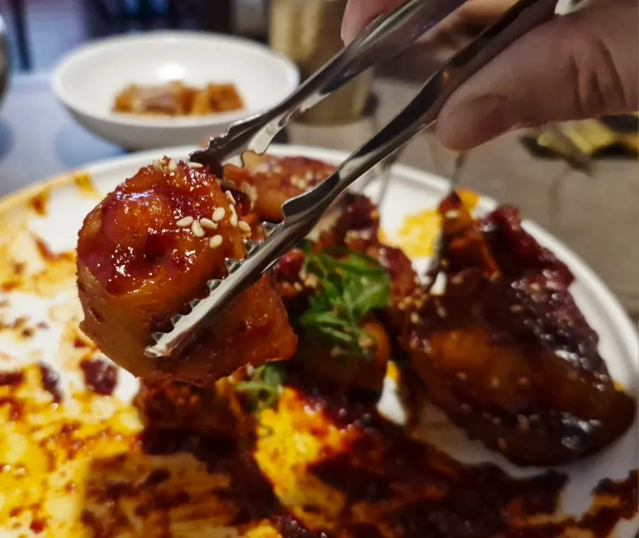 Picking up pork tail jjim with personal tongs