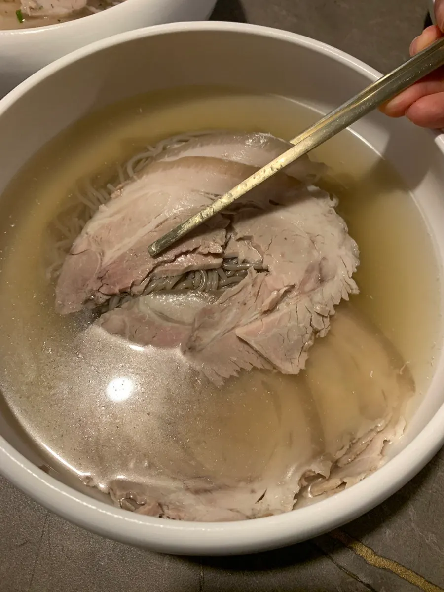 A piece of naengmyeon meat topped with seasoning sauce