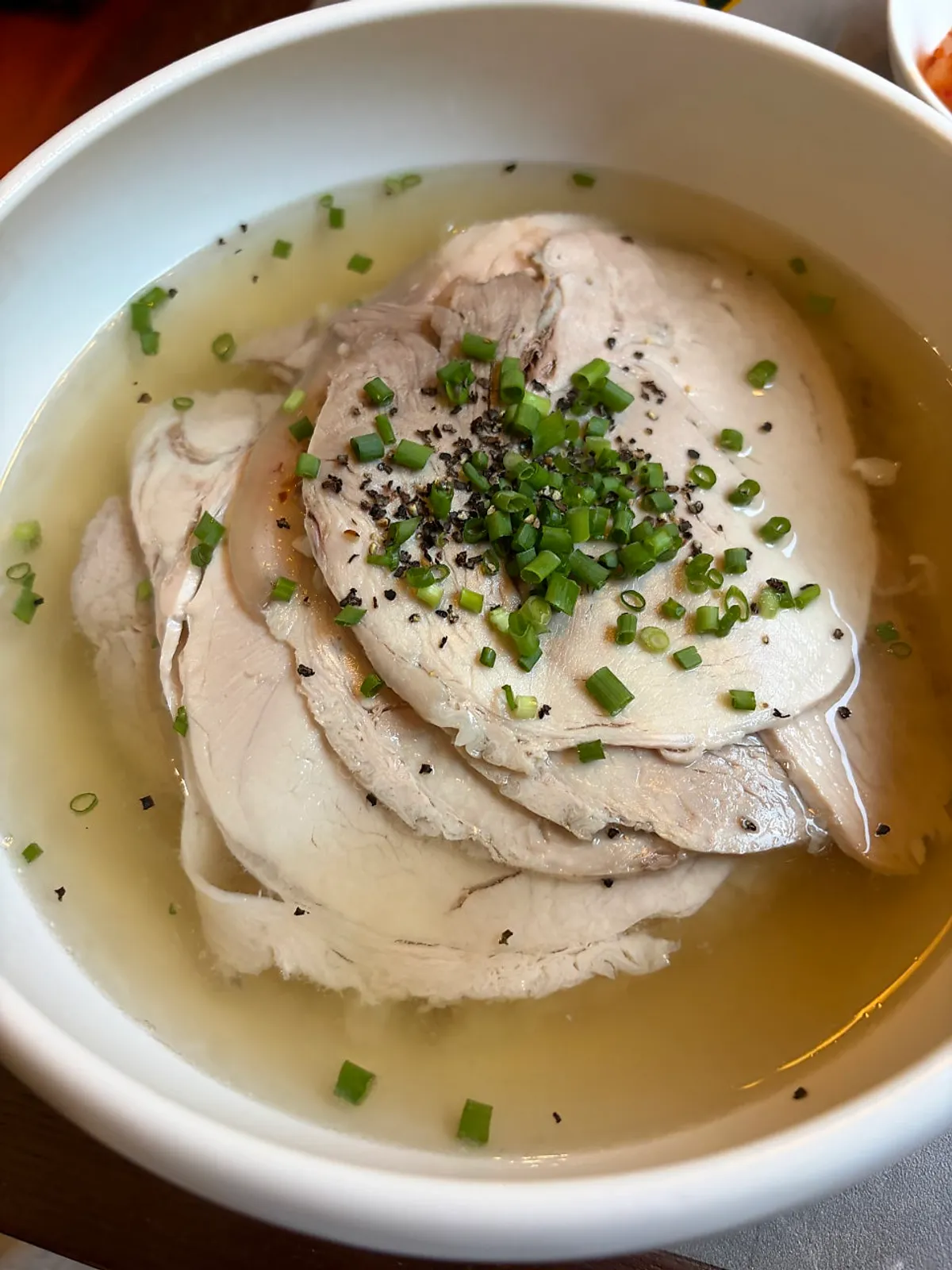 A bowl of Anok's clear gomtang with side dishes