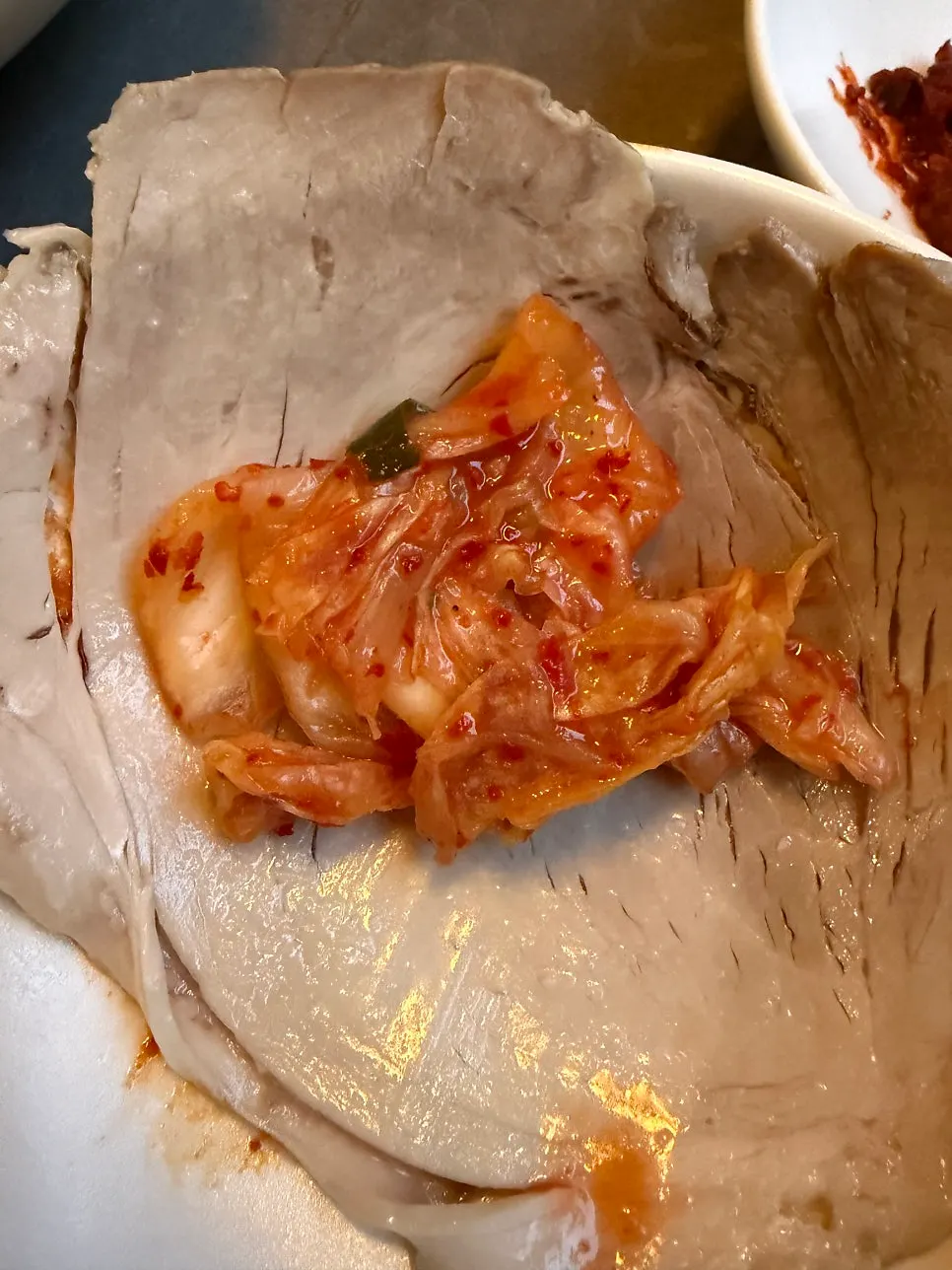 A piece of gomtang meat dipped in seasoning sauce