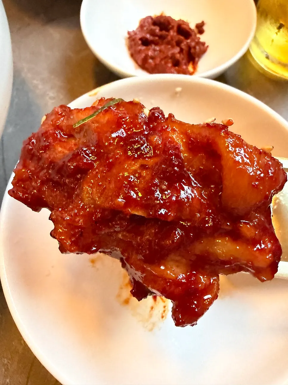A piece of pork tail jjim held with chopsticks
