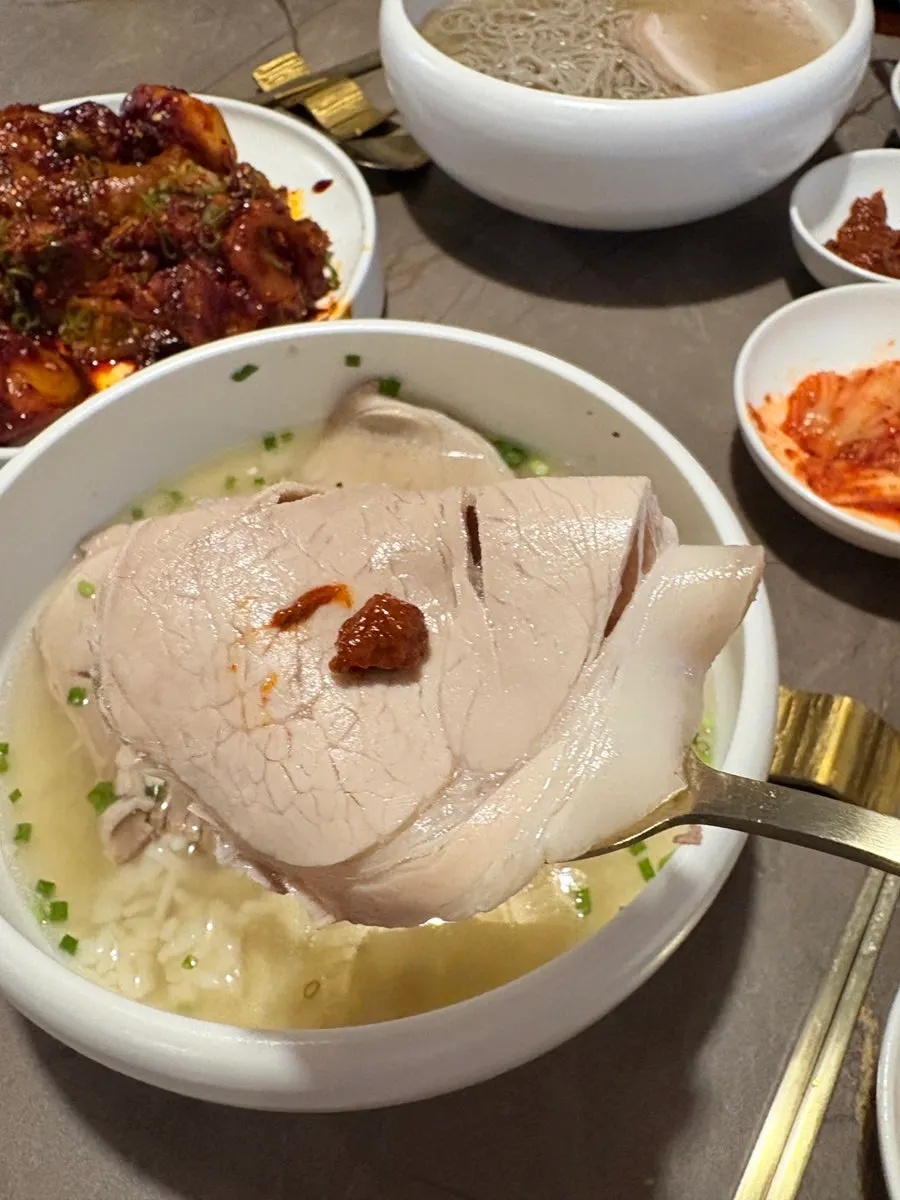 A spoonful of gomtang loaded with meat