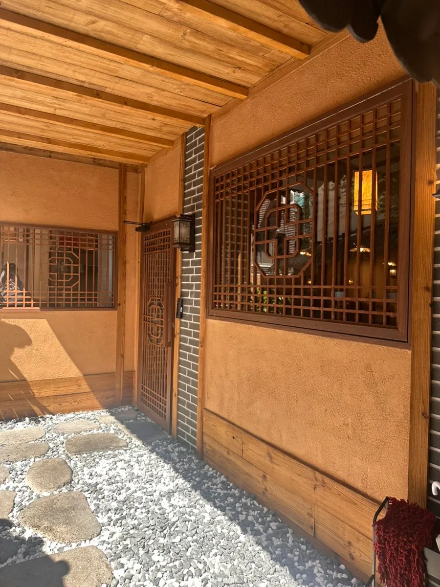 Entrance of Anok with a tiled roof and wooden gate