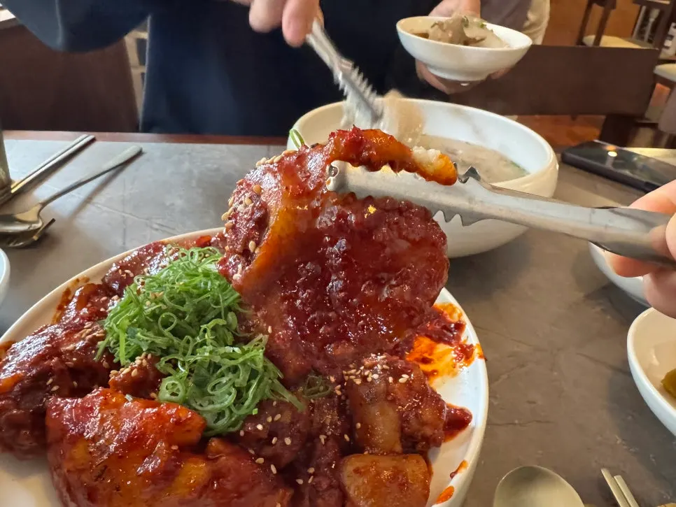 Table spread of gomtang, Pyongyang naengmyeon, and pork tail jjim