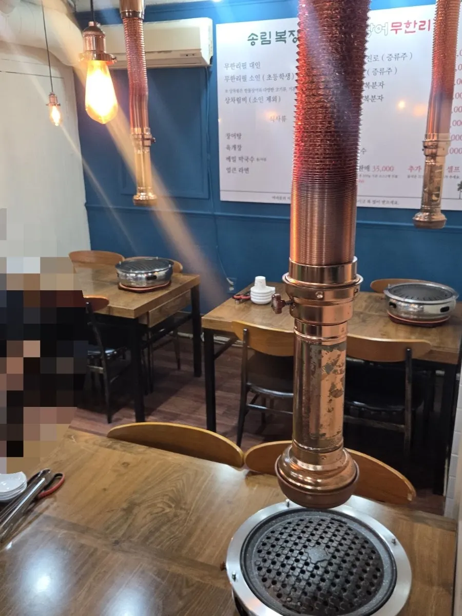 나무 테이블과 파란 벽의 매장 내부