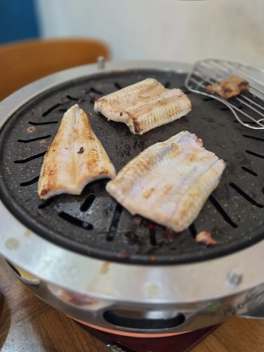 노릇하게 익은 장어를 집는 모습