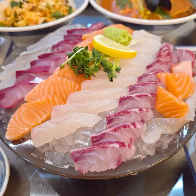 Assorted sashimi, hoe-deopbap, and seafood ramen meal