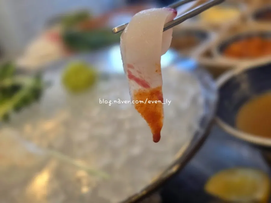 A piece of sashimi dipped in special makjang sauce