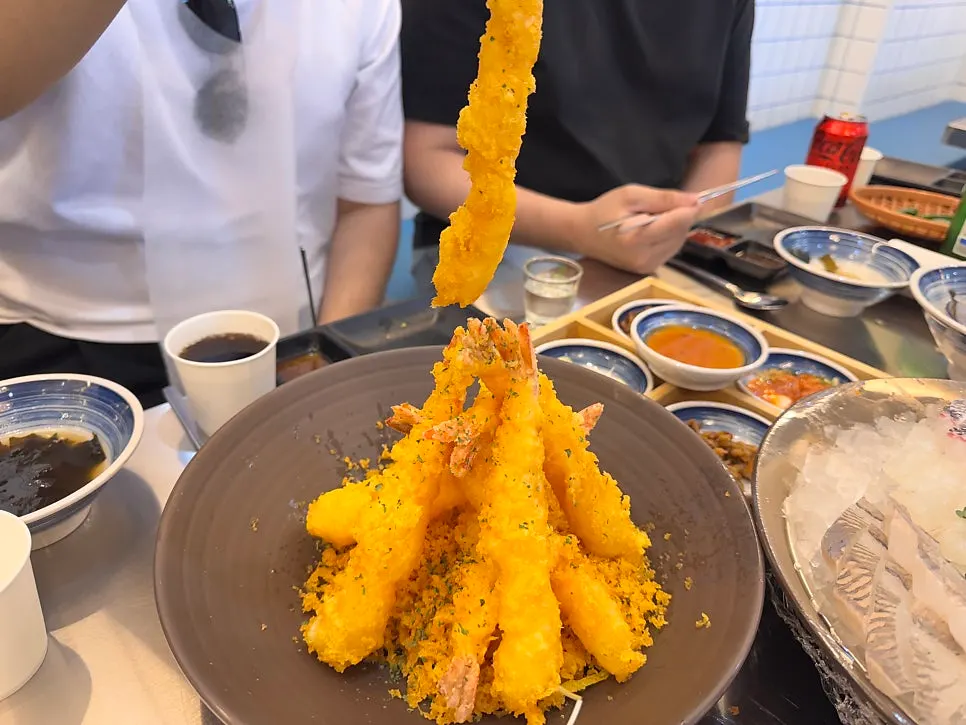 Picking up a piece of sashimi with chopsticks