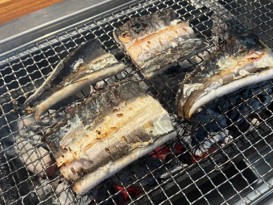 Raw eel placed skin-side down on the grill