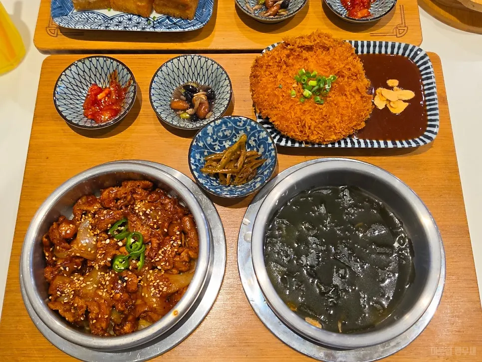 Aged kimchi pork belly pot rice served with seaweed soup and side dishes