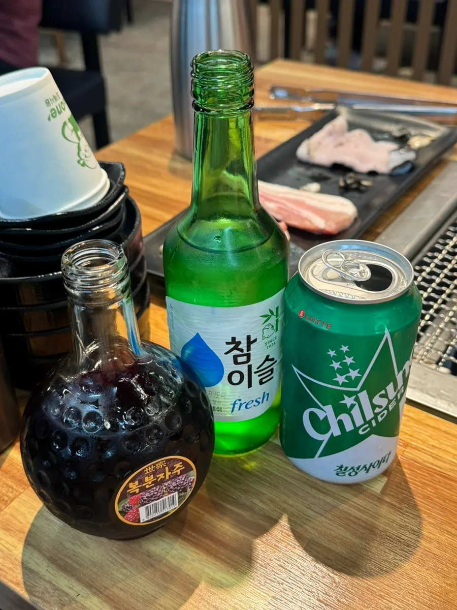 A glass of boksosa, bokbunja mixed with soju and cider