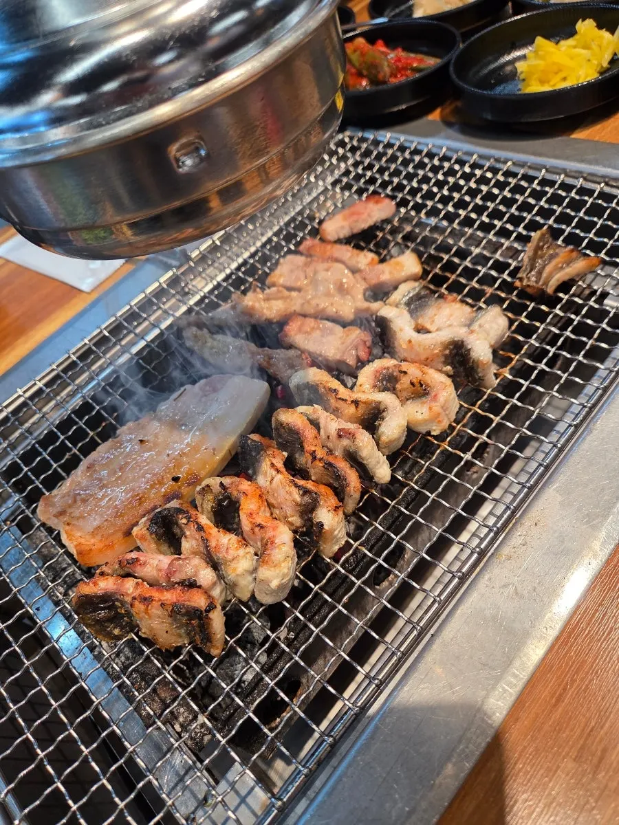 Pork belly and chicken neck grilling alongside the eel