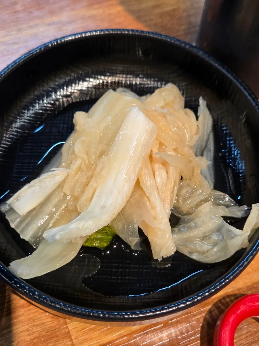 Yellow ginger strips served alongside the eel