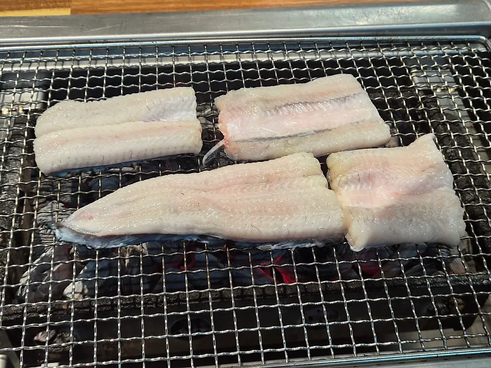 Plump eel body and tail placed on the grill