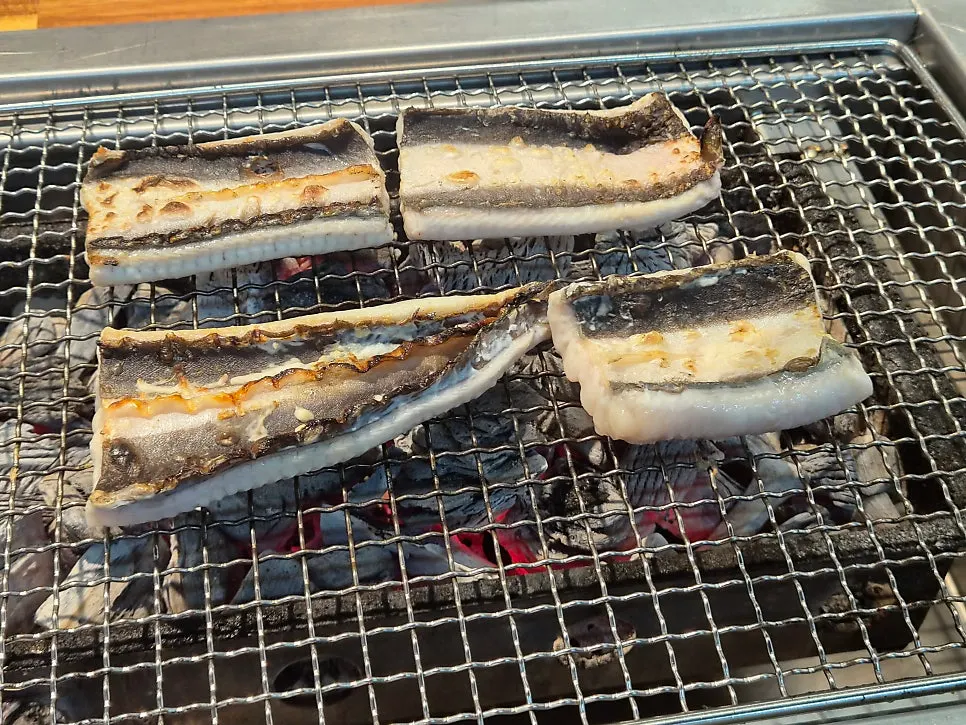 All-you-can-eat eel being flipped on the grill