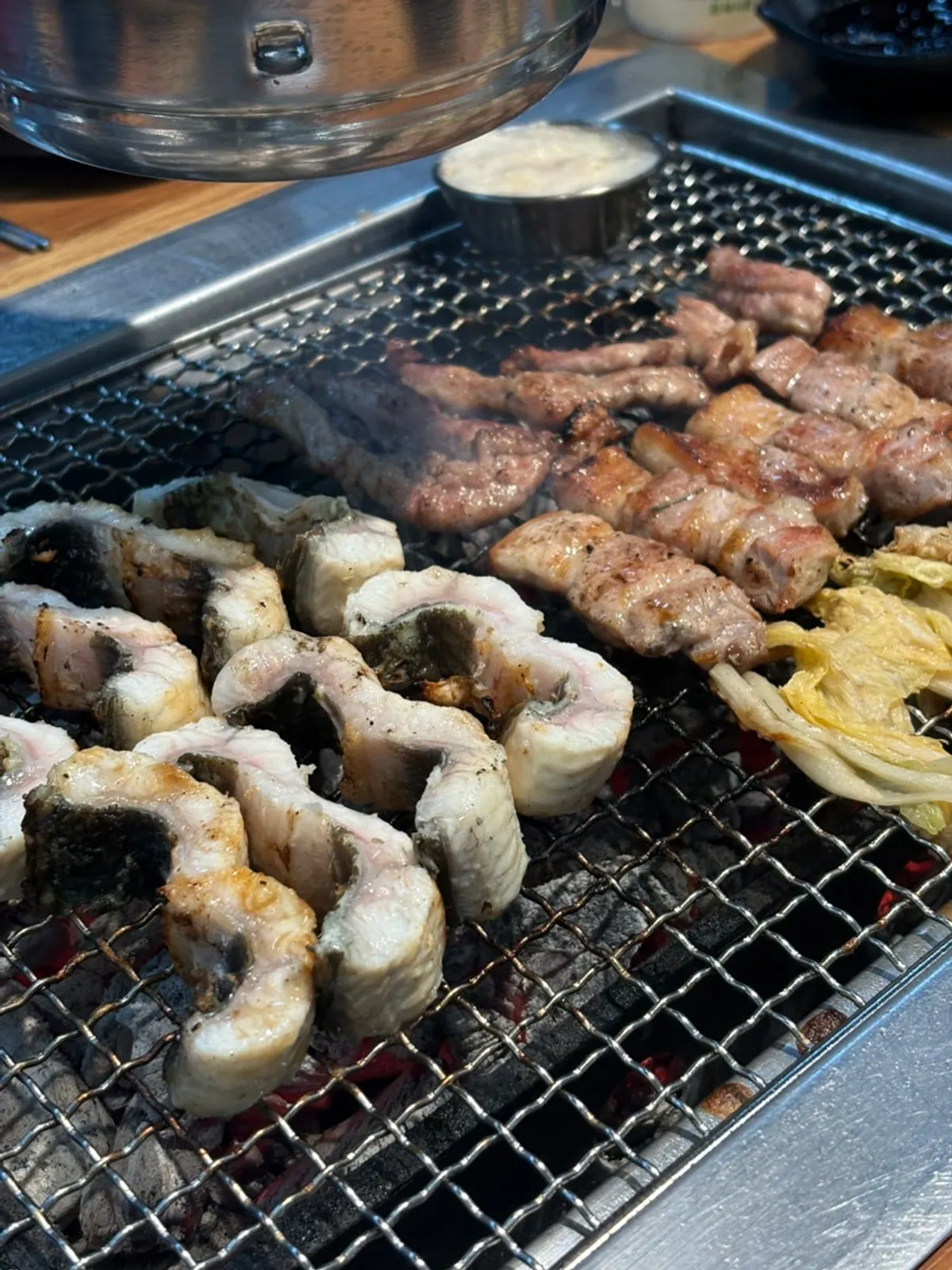 리필해 온 두툼한 민물장어를 굽는 숯불 불판