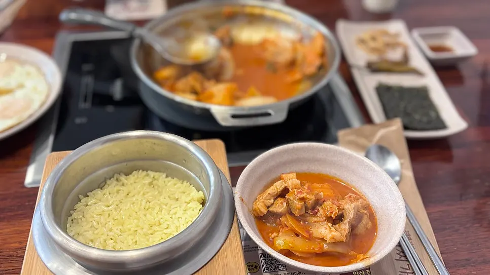 Full spread of the stone-pot rice kimchi jjigae set for two