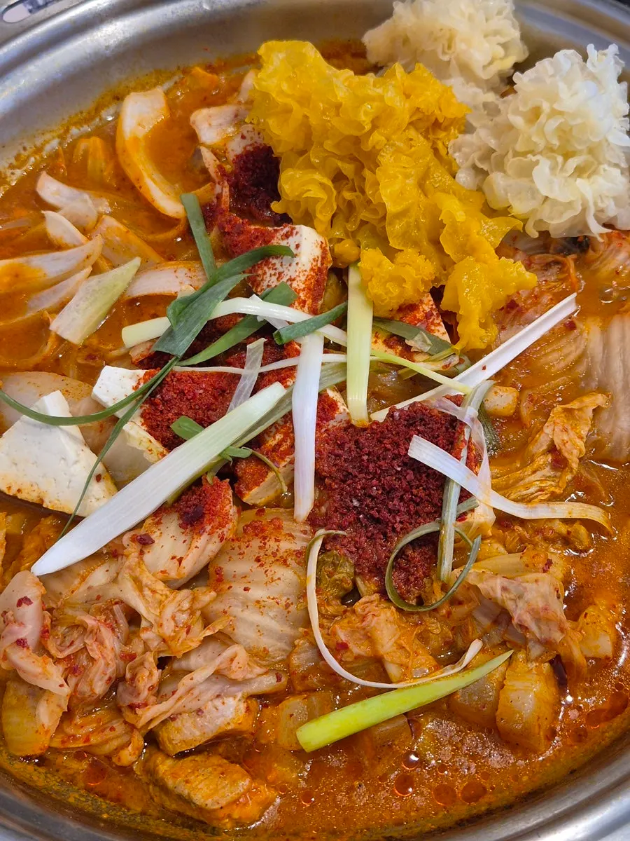Pot of kimchi jjigae full of kimchi and pork