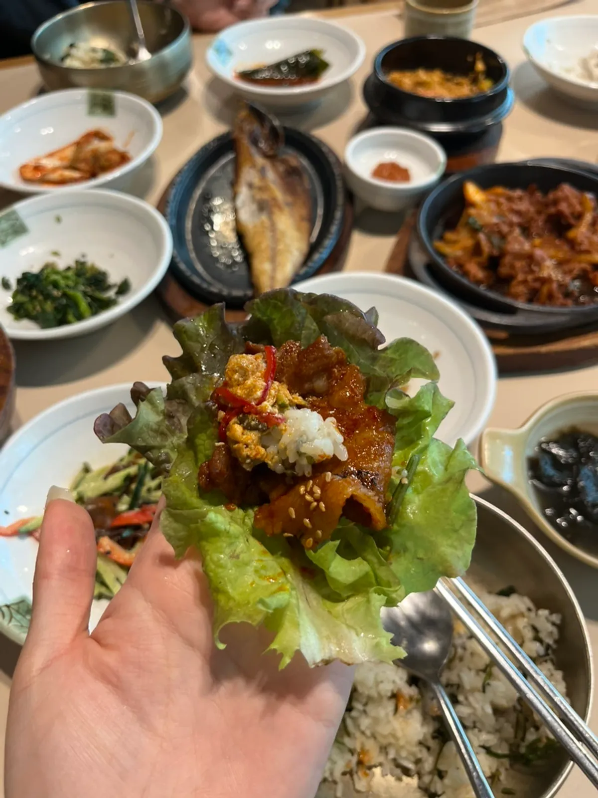 Lettuce wrap piled with pork, doenjang dip, and gondre rice