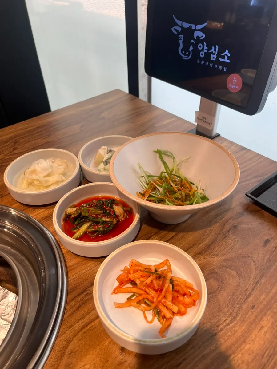 Kimchi, shredded scallions, and salad side dishes