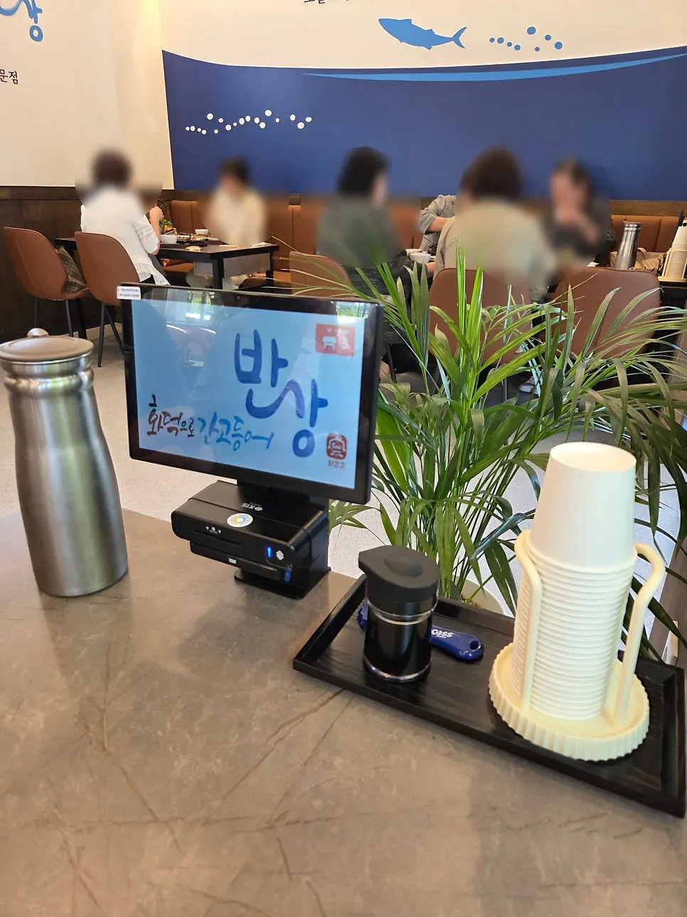 큰 창으로 햇빛이 드는 넓은 테이블 간격의 홀