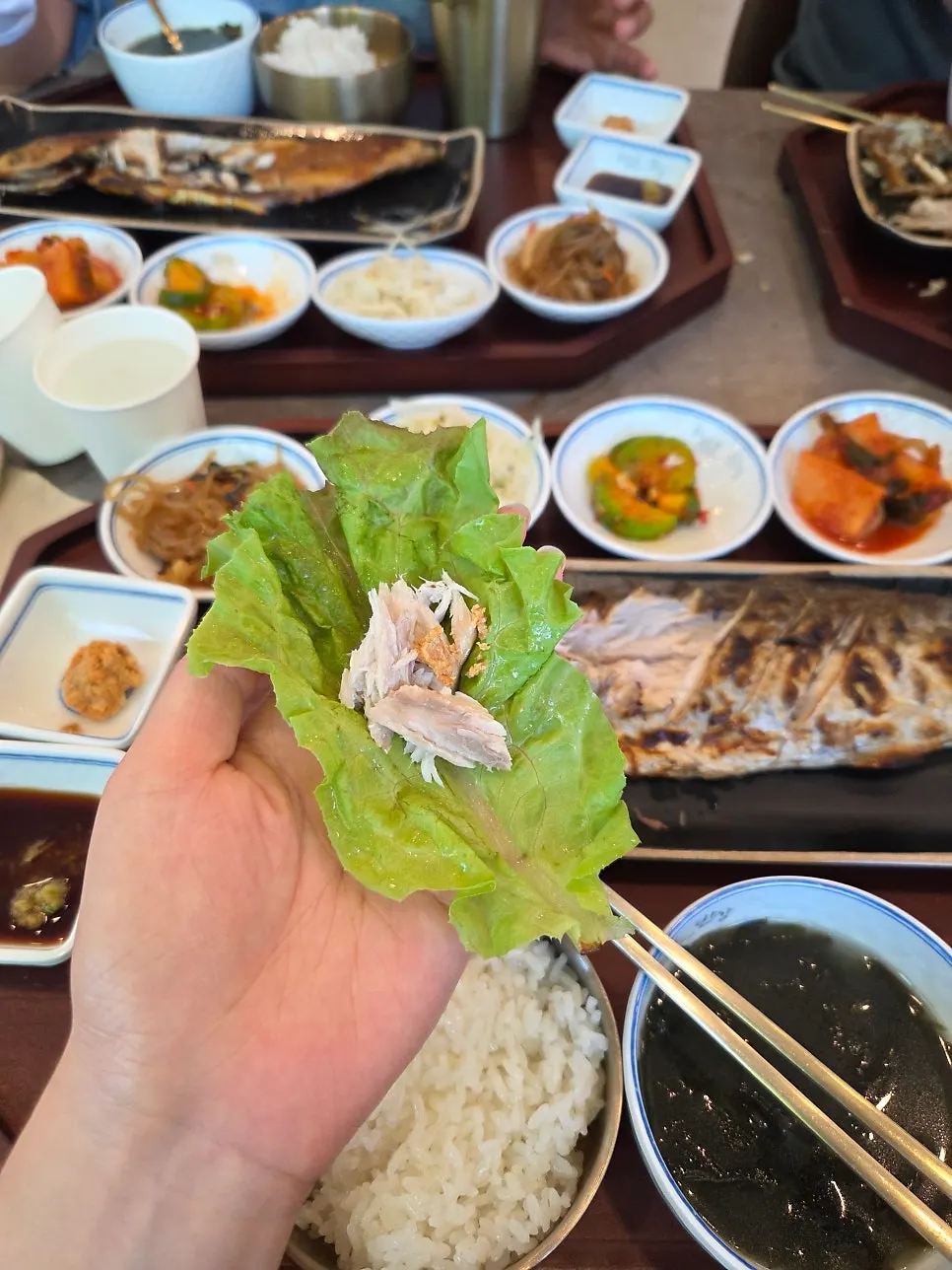 쌈채소에 생선 살과 밥을 올린 쌈