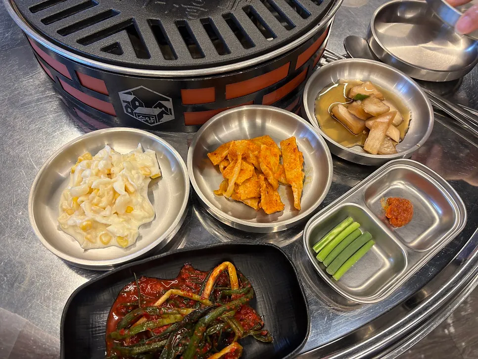 A spread of basic side dishes including salad, stir-fried fish cake, and green onion kimchi