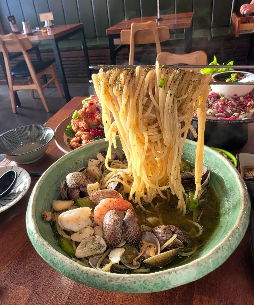 Cận cảnh pasta hấp rượu rắc lá basil tươi