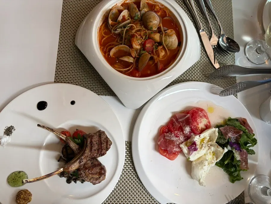 Full spread of lamb chop steak, pasta, and salad