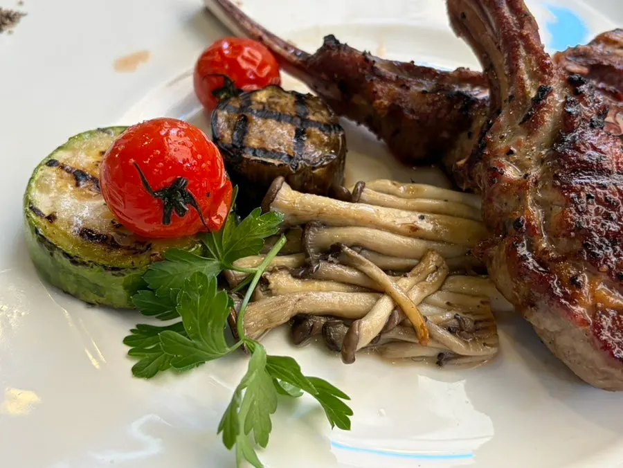 Grilled garnish of zucchini, cherry tomatoes, and mushrooms