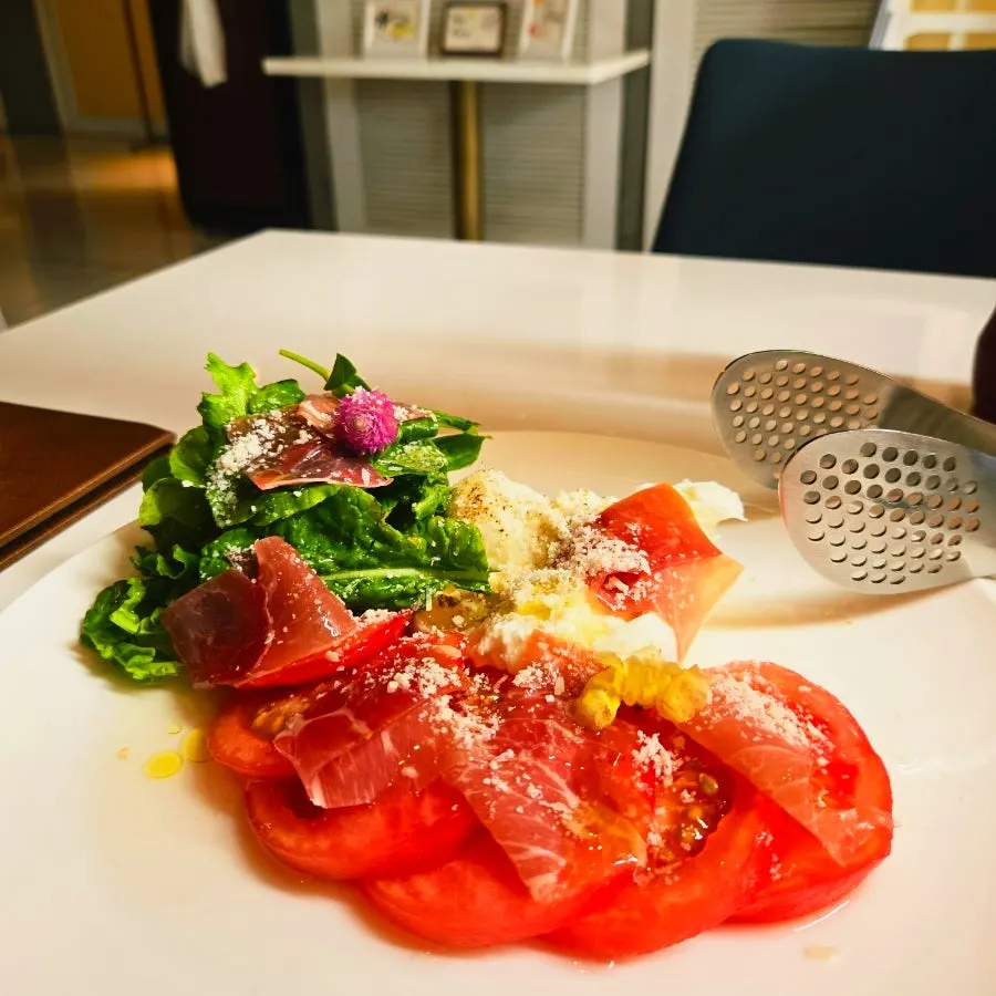 Table setting with lamb chop steak and burrata cheese salad
