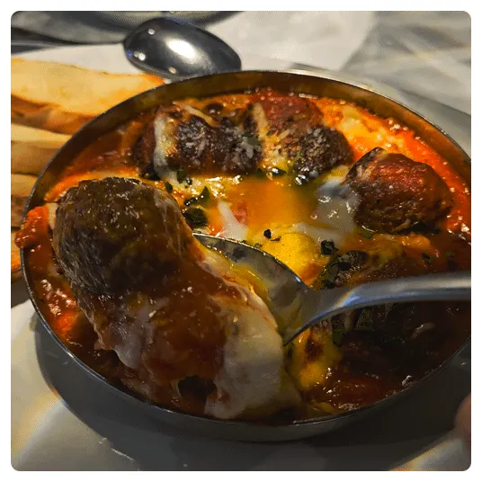 Close-up of meatball gratin full of tomato sauce