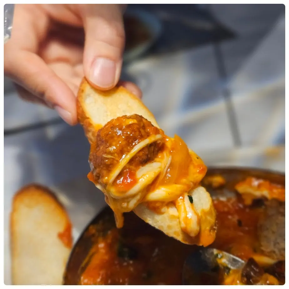 Meatballs and thick sauce piled onto baguette