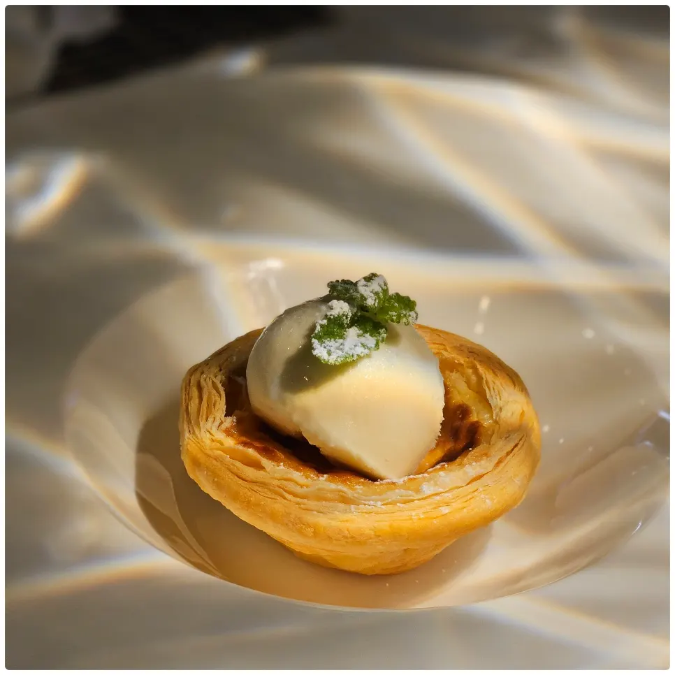 Egg tart dessert topped with vanilla ice cream