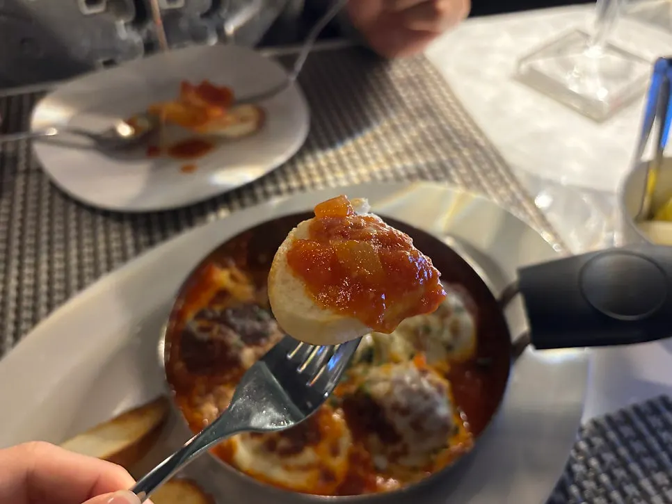 Dipping baguette into the gratin sauce