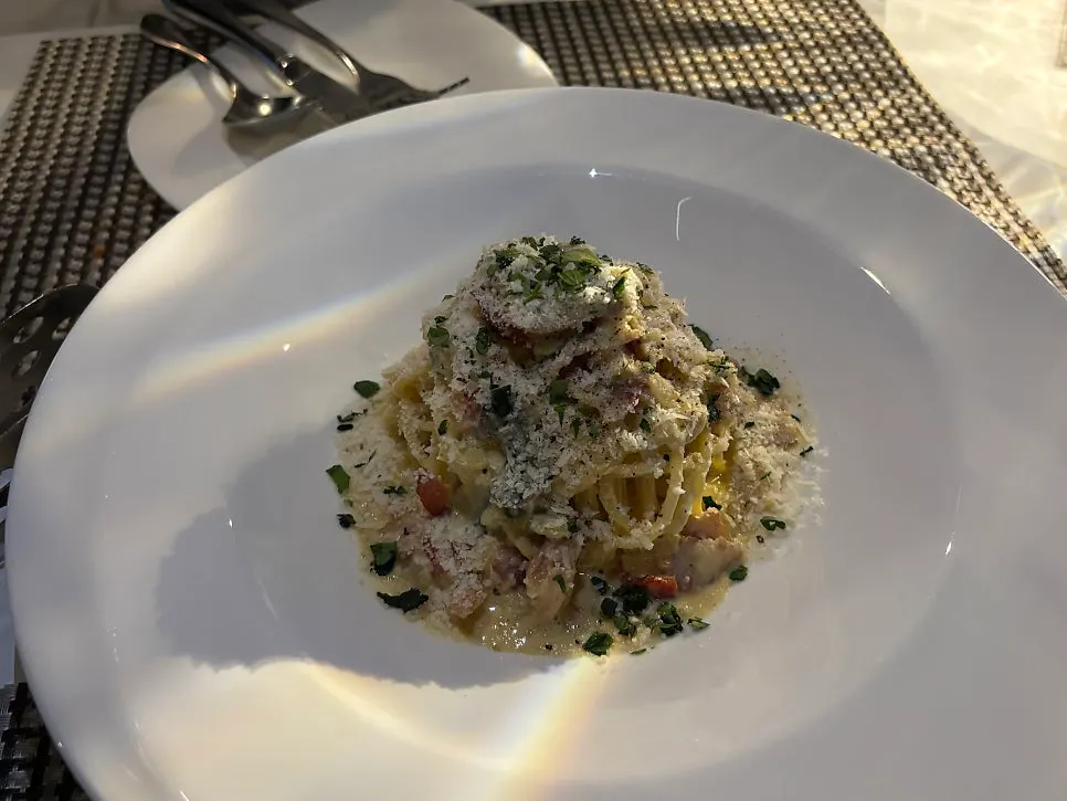 Close-up of carbonara topped with bacon