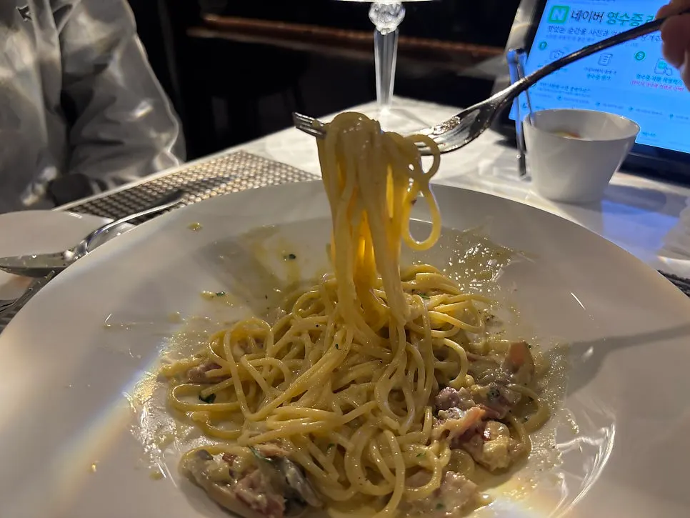Lifting a forkful of al dente carbonara noodles
