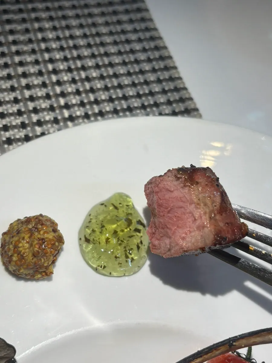 Dipping the lamb rack into sauce