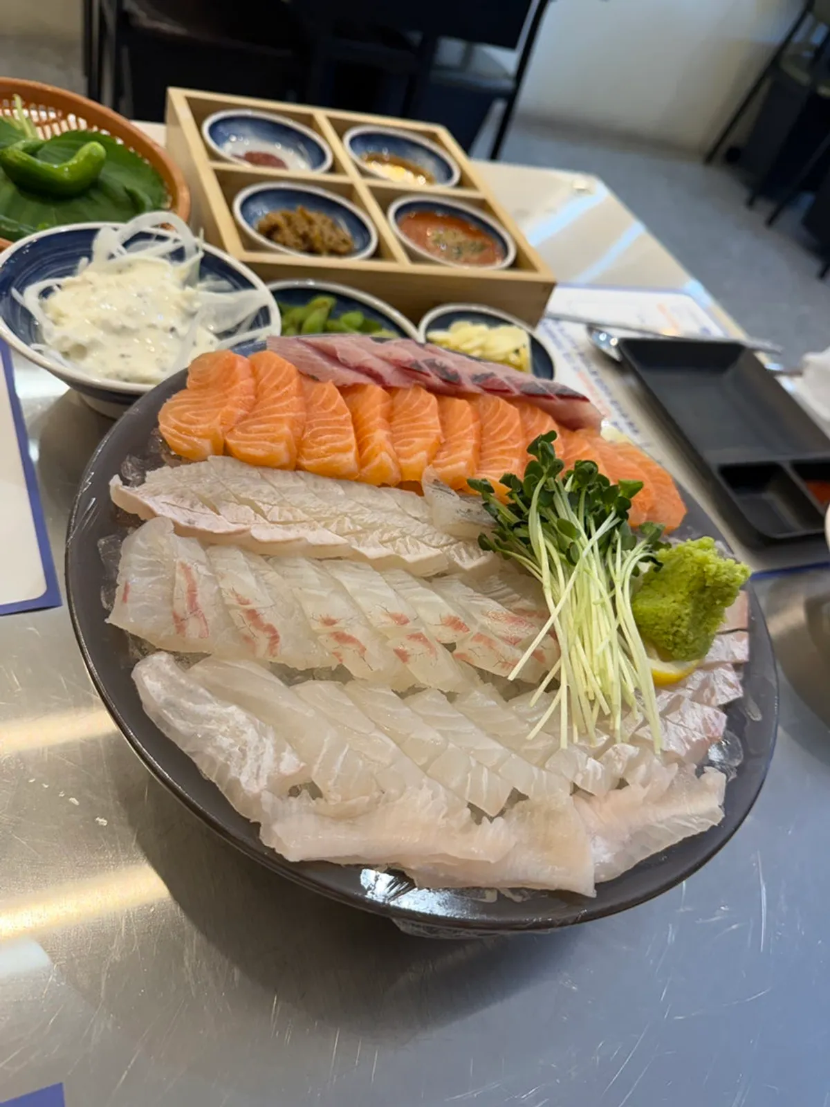 Assorted sashimi on ice with banchan side dishes