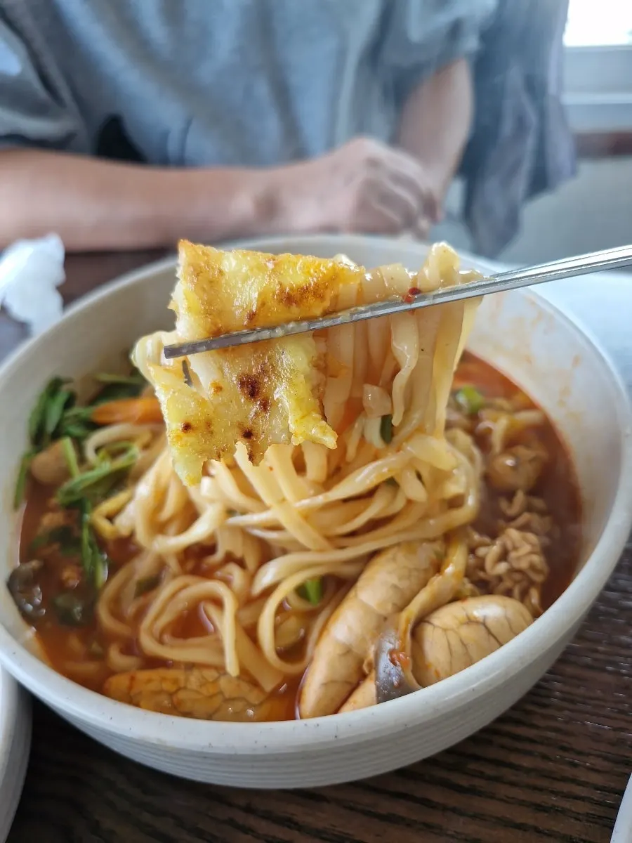 Close-up of the roe and milt kalguksu broth and noodles