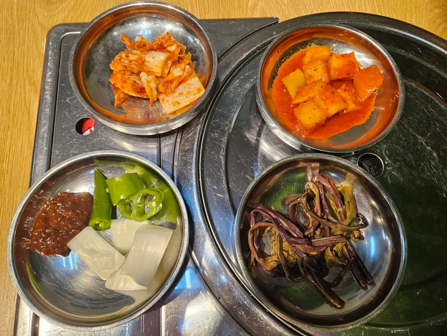 Basic side dish spread of kimchi, kkakdugi, fernbrake, onion, and ssamjang