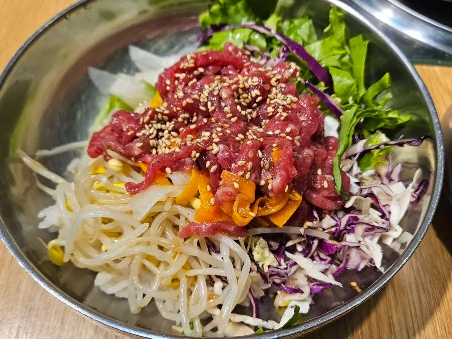 A bowl of yukhoe bibimbap topped with raw beef tartare