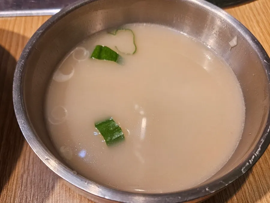 Table setting with yukhoe bibimbap served alongside seolleongtang broth
