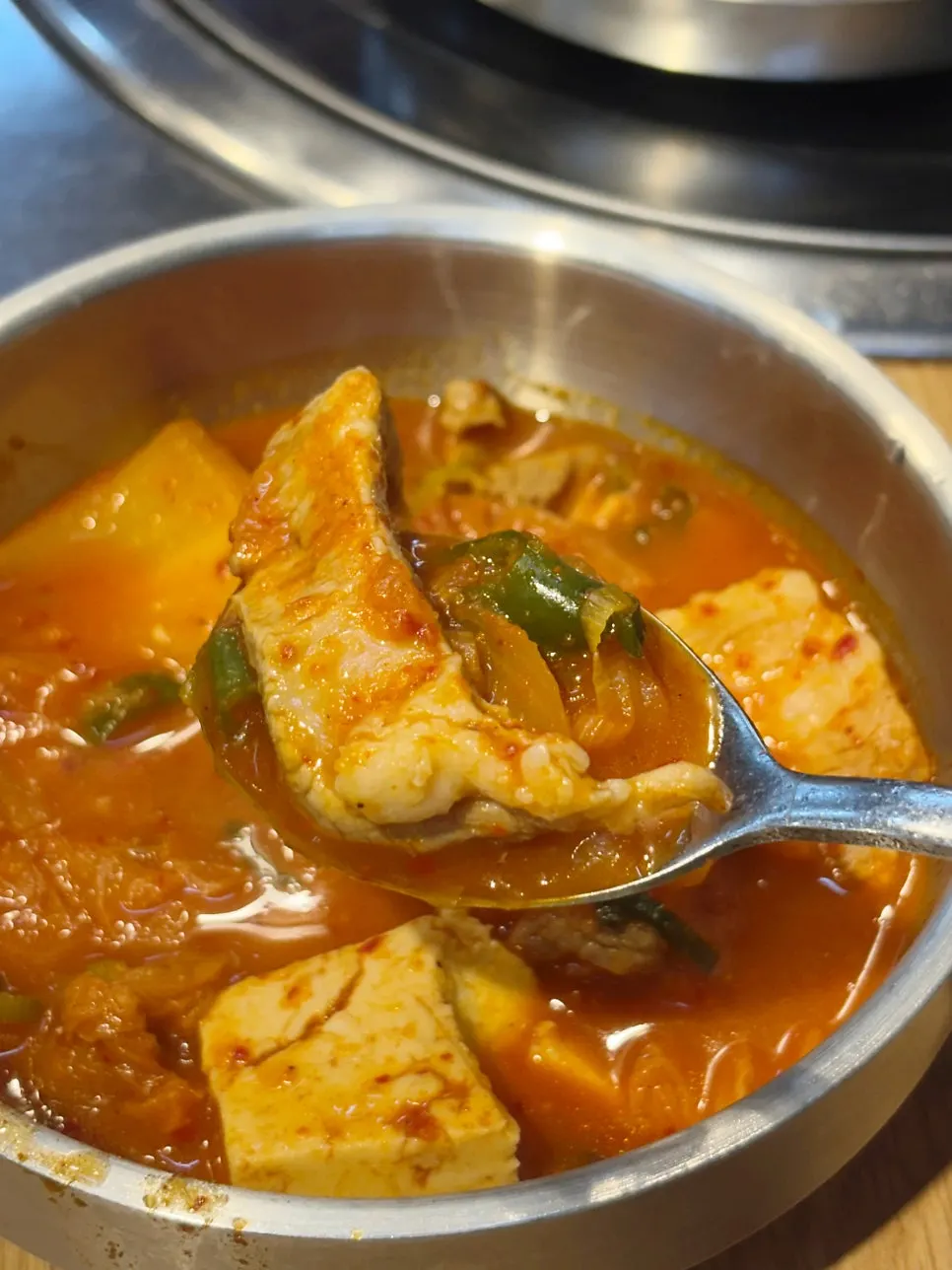 Stone bowl of kimchi jjigae loaded with meat