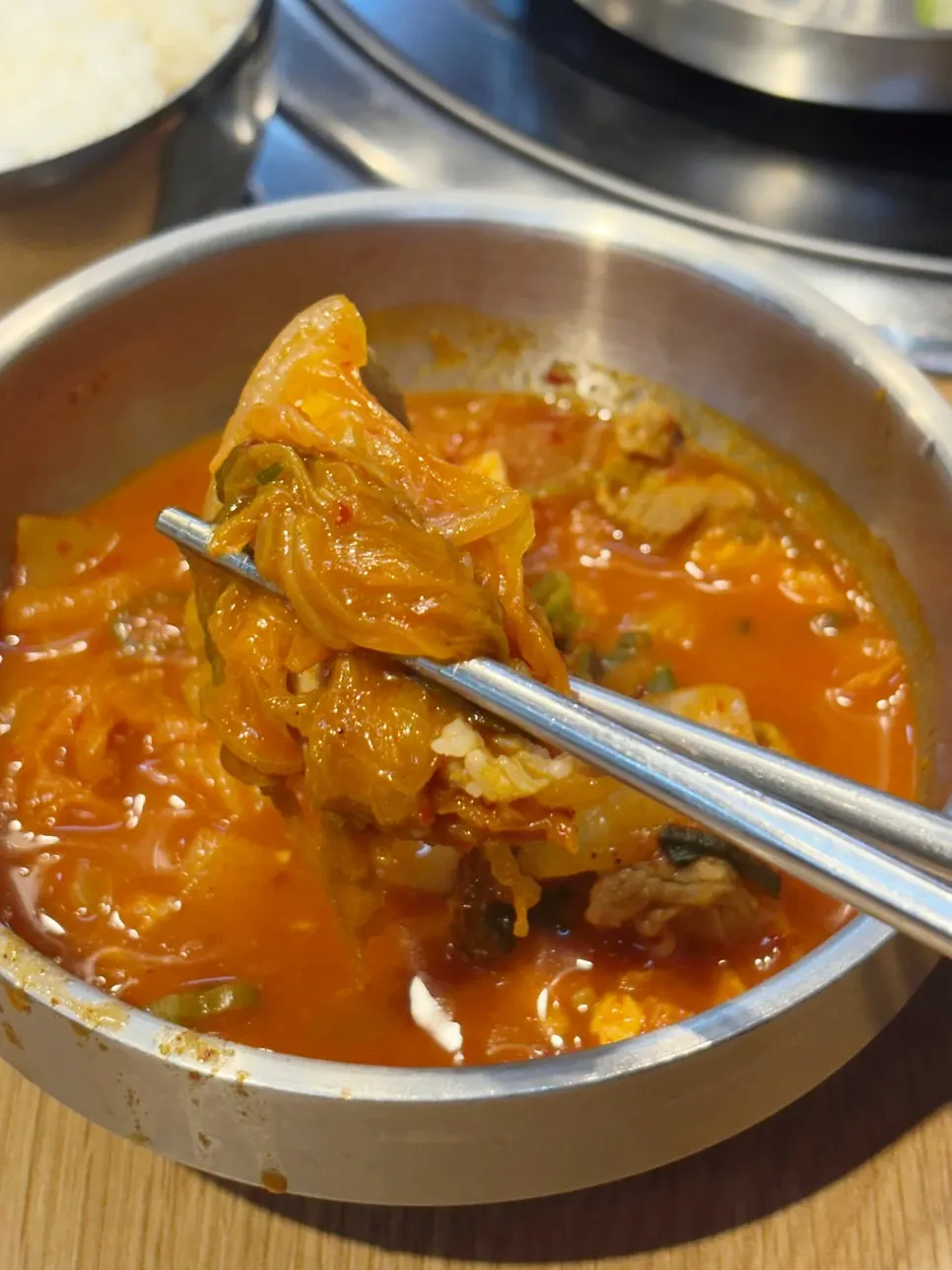 A bite of kimchi jjigae meat eaten with rice