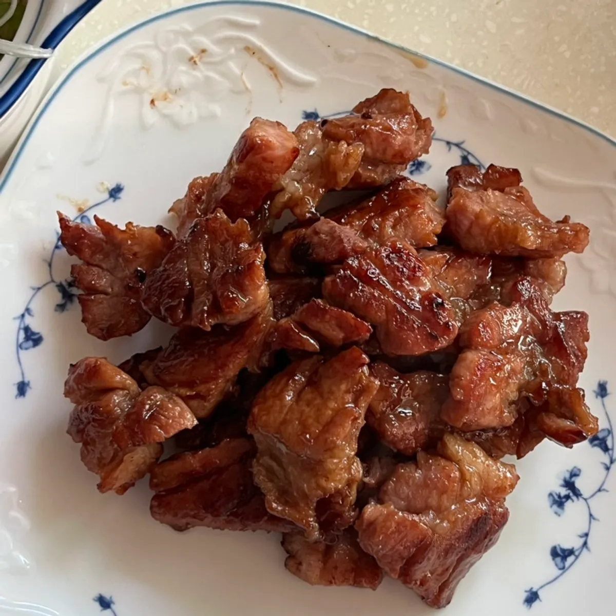 A plate of fully grilled wang-po galbi with scallion strips